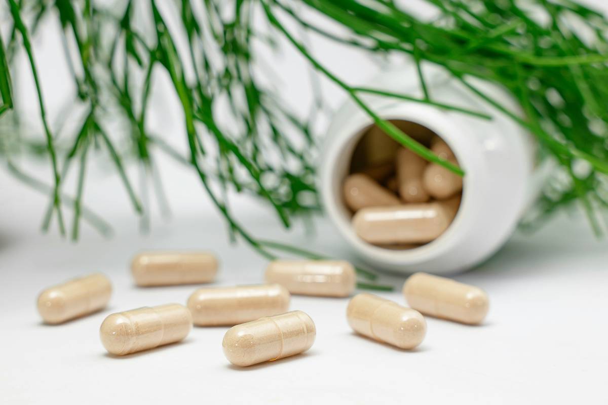 Men's Health supplement guide showing tongkat ali root extract bottle next to fitness gear